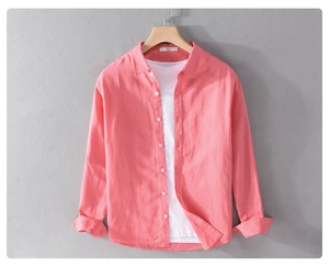 Close-up of coral cotton linen shirt texture and classic collar detail on wooden hanger
