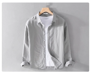 Close-up of light gray linen shirt texture with classic buttons and wooden hanger