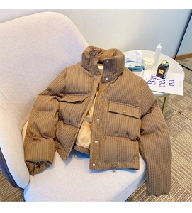 Detail of brown corduroy puffer jacket showing the stand collar and smooth inner lining
