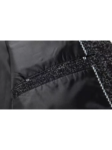 Detailed macro view of the inner lining and high-quality tweed stitching of the jacket
