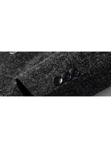 Detail of dark grey textured suit sleeve featuring three black polished buttons