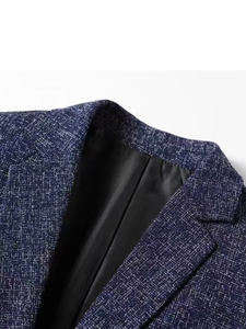 Detailed close-up of dark blue textured blazer lapel showing fine white fiber pattern