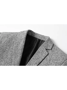 Detail of grey slim fit blazer showing notch lapel and grainy tweed fabric texture