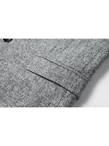 Detailed macro view of the grey textured fabric and classic welt pocket on the blazer