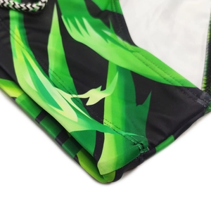 Detail of tropical green leaf print swim trunks with premium stitching and woven drawstring