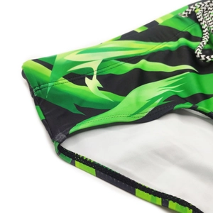 Detailed close-up of men's swimming briefs featuring green leaf pattern and adjustable drawstring