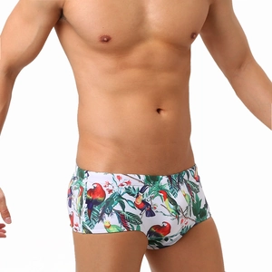 Men's square-cut swim trunks with tropical parrot and floral print on white background