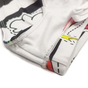 Macro detail showing flatlock stitching and vibrant graphic prints on white swimwear fabric
