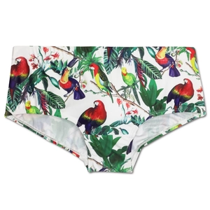 Close-up of men's swim trunks with tropical parrot and palm leaf prints on white background
