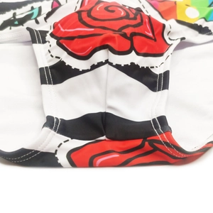 Detailed macro view of men's floral swim trunks with rose pattern and bold stripe texture