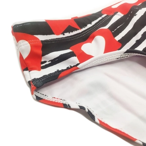 Detailed view of striped heart pattern fabric and reinforced stitching on swim briefs