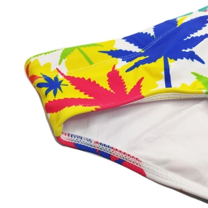 Detail view of tropical leaf pattern and reinforced stitching on white swim briefs