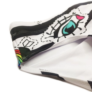 Close-up of rainbow striped trim and pop art lip print on men's stretch swim briefs
