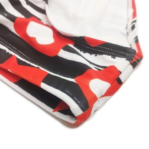 Detail of red heart print and black stripes on men's bikini swimwear fabric and stitching