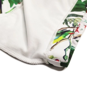 Close-up of tropical bird and leaf prints on high-elastic white fabric with flatlock seams