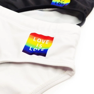 Detail van Love Is Love regenboogprint op zwart-witte elastische heren zwemslips
