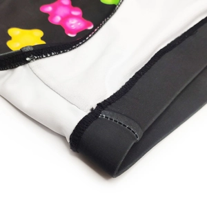 Detailed close-up of colorful gummy bear print on black swim trunks with flatlock seams