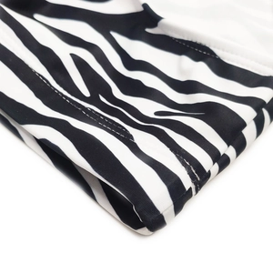 Macro view of zebra print swim briefs showing premium double-needle stitching and elastic fabric