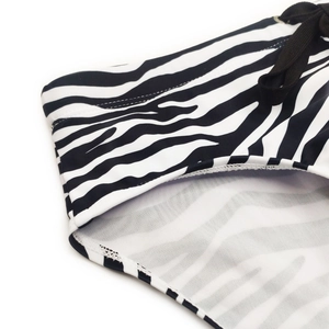 Detail of zebra stripe men's swim briefs featuring black drawstring and elastic fabric