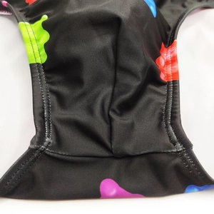 Close-up of high-elasticity men swim briefs featuring colorful splatter print and durable stitching