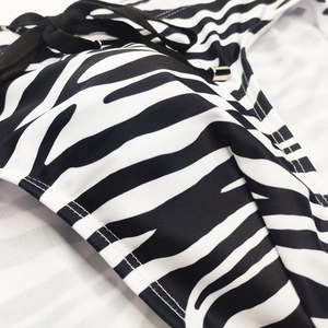 Close-up of zebra stripe print swimwear with adjustable black drawstrings and metal tips
