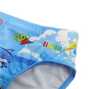 Close-up of sky blue swim briefs featuring cartoon sharks and smooth elastic fabric