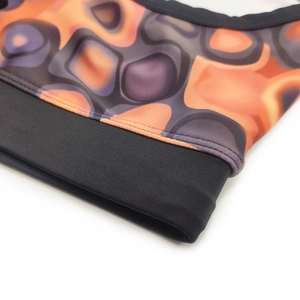 Macro detail of men's swim briefs showing abstract liquid pattern and elastic waistband