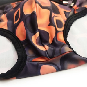Detail of men's swim trunks featuring coffee abstract geometric print and black drawstring