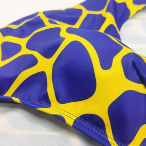 Macro detail of blue and yellow geometric pattern on stretch fabric with flatlock stitching