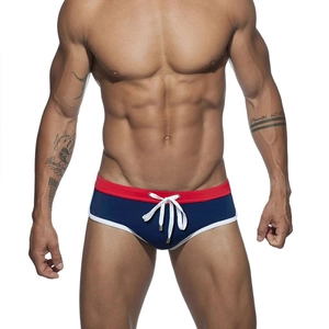 Detail of navy blue mens swim briefs with red waistband, white drawstrings and piping