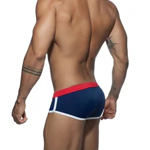 Rear view of men's navy blue swim trunks with red elastic waist and white piping trim