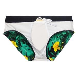 Detailed view of men's swim briefs featuring tropical green leaf and yellow flower prints