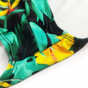 Detail of tropical leaf and floral print swimwear fabric with precision double stitching