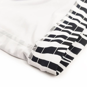 Detail shot of high-quality stitching on white men's swimwear with zebra stripe patterns
