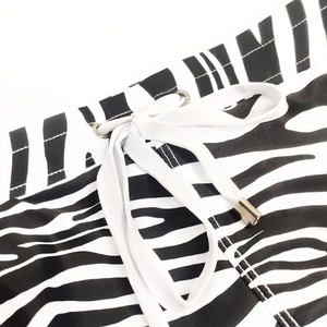 Close-up of zebra pattern swim trunks with white drawstring and metallic tips
