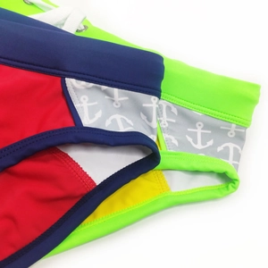 Close-up of color-block swim briefs with nautical anchor print and adjustable drawstrings