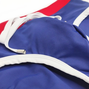 Close-up of royal blue men's swim briefs featuring red waist detail and white drawstring