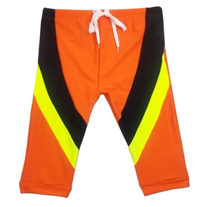 Close-up of quick-dry swim trunks with orange, black, and yellow contrast color blocks