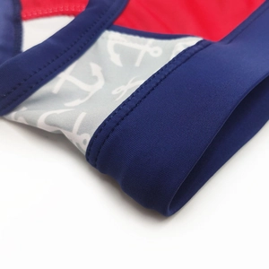 Detailed macro view of navy blue swimwear fabric with anchor motif and reinforced stitching