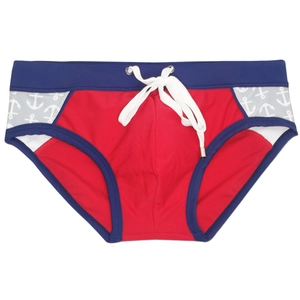 Detail of red men's swim briefs featuring navy blue trim and anchor print patterns