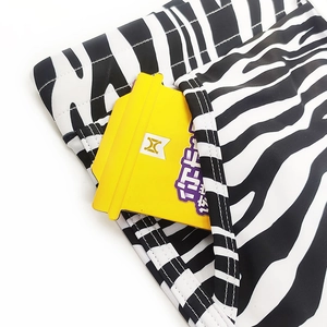 Close-up of zebra stripe men's swim trunks featuring a side pocket and elastic fabric