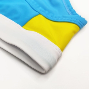 Macro shot of tricolor swimming briefs showing precise double-stitch seams and elastic fabric
