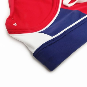 Detail of red, white, and blue low-waisted swim briefs featuring reinforced stitching