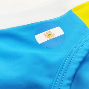 Close-up of Argentina flag logo and stitching on men's blue elastic swim briefs