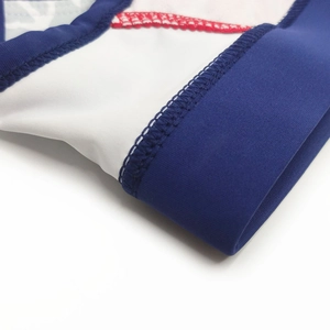 Macro detail of elastic blue waistband with red zigzag stitching on white swimwear fabric