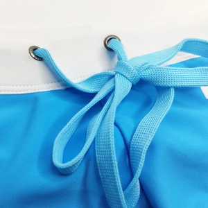 Detail of blue and white swimwear waist with woven drawstring and branded metal eyelets