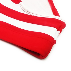 Vue macro montrant les coutures plates et le détail du tissu rayé rouge et blanc du maillot