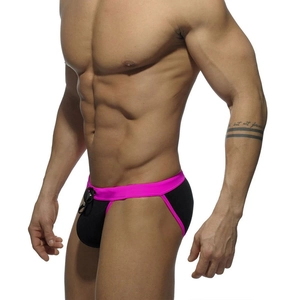 Detail view of men's low-rise swim briefs featuring black and neon pink color blocking