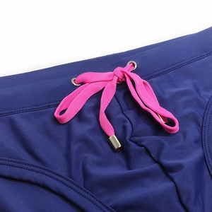 Detail of navy blue swim trunks with pink drawstring and engraved silver metal eyelets