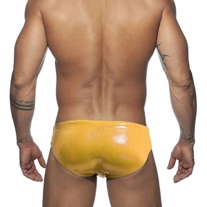 Macro back view of shiny gold metallic men's swim briefs with low-waisted fit